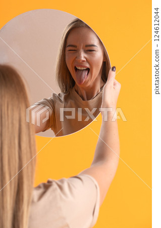 Woman Making a Playful Face in Mirror 124612044