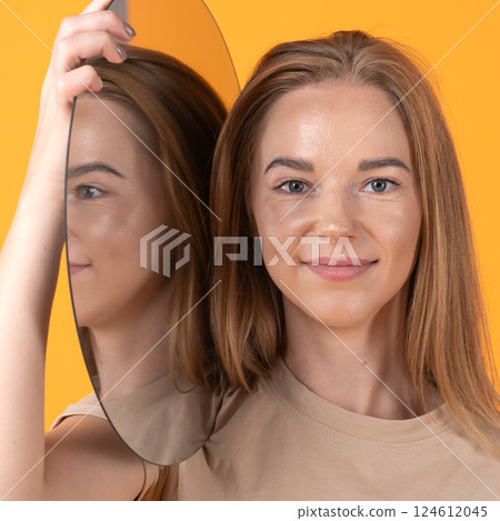 Woman with Mirror on Orange Backdrop 124612045