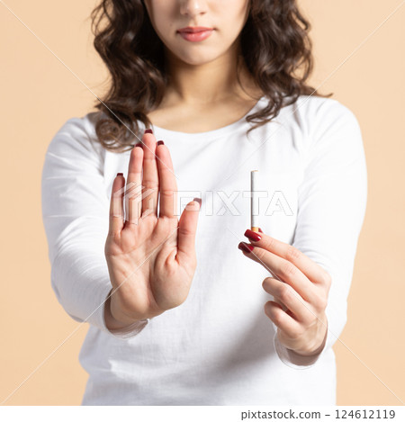 Woman with cigarette and no smoking hand palm sign 124612119