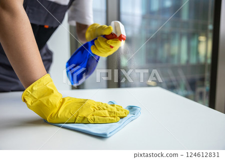 Woman from cleaning team disinfecting the table surface 124612831