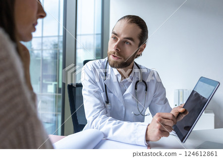 Surgeon in hospital using digital tablet discussing healthcare procedures with patient Surgeon in hospital using digital tablet discussing healthcare procedures with patient 124612861
