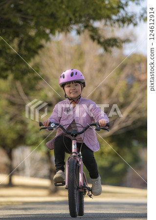 Girl riding a bicycle in the park 124612914