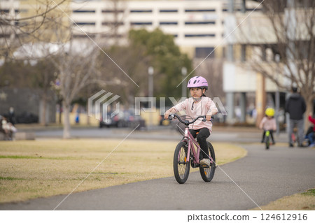 Girl riding a bicycle in the park 124612916
