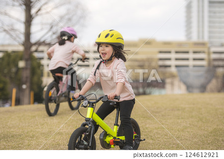 Sisters riding bicycles in the park 124612921