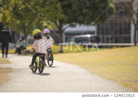 公園裡騎自行車的女孩的背影 124612923