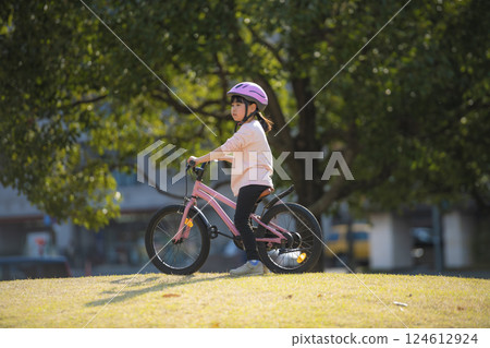Girl riding a bicycle in the park 124612924