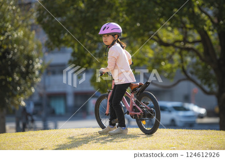 Girl riding a bicycle in the park Girl riding a bicycle in the park 124612926