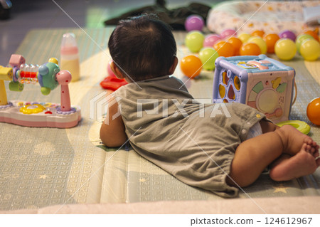 Baby In Bodysuit Is Crawling On A Soft Mat 124612967