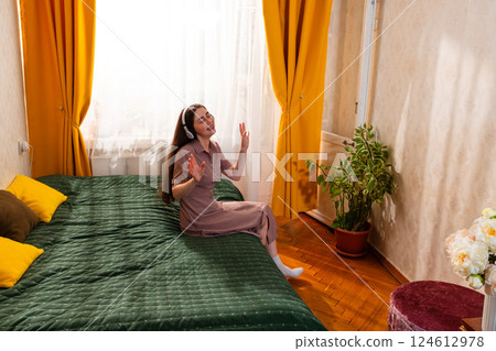 Relaxed young woman embracing the moment with music and singing. Wide shot 124612978