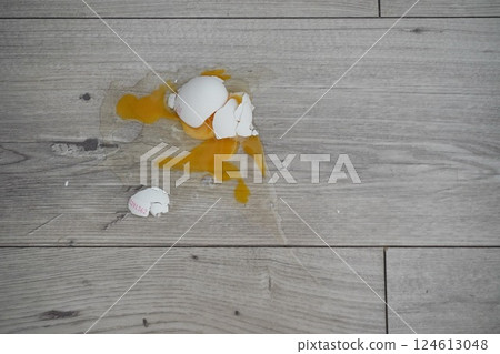 Close up the white egg fall and broken on wooden floor. crushed egg 124613048