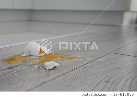 Close up the white egg fall and broken on wooden floor. crushed egg 124613050