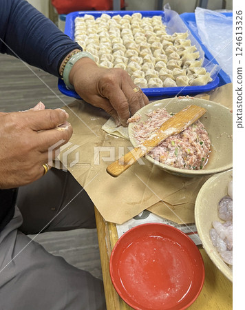 Filming the waiter skillfully making wontons in a restaurant 124613326