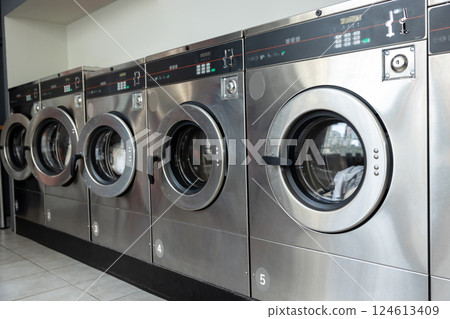 Rows of industrial laundry machines in the laundromat 124613409