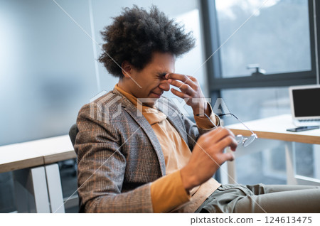 Businessman holding glasses feel eye strain stressed overworked man feeling pain in his eyes 124613475
