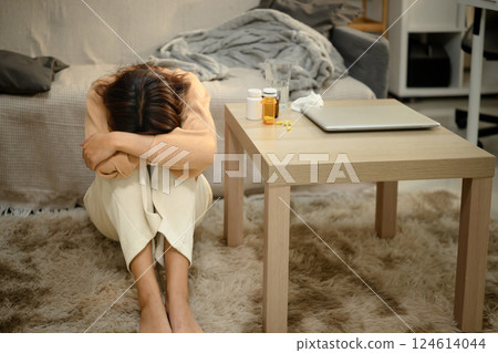 Depressed young woman sitting on the floor with her head buried. Mental Health concept 124614044