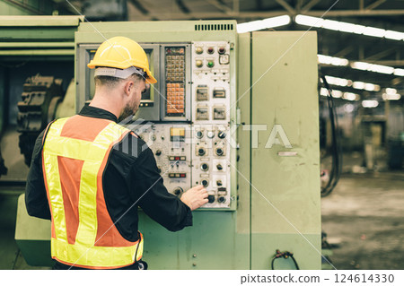 Professional technician engineer male operate control heavy industry machine CNC in factory. 124614330