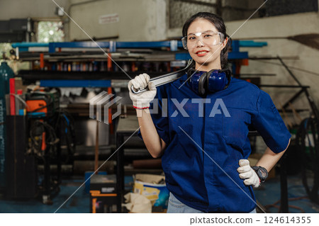 Portrait engineer women working in Lathe shop with metal machinery lathe milling machine, confident smart looking camera. 124614355