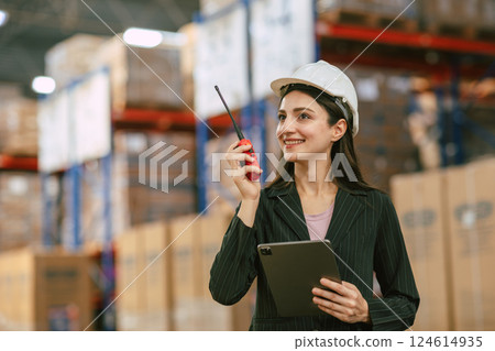 Business women working in cargo warehouse manage operating control products inventory with radio Business women working in cargo warehouse manage operating control products inventory with radio 124614935