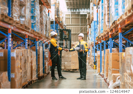 Warehouse workers join team together deal shaking hand in warehouse building in logistic industry Warehouse workers join team together deal shaking hand in warehouse building in logistic industry 124614947