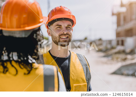 Construction worker happy smile. Engineer male wearing safety vest and helmet at construction site 124615014