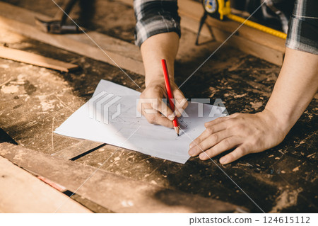 Carpenter man hand craft sketch drawing design wood furniture in wood workshop making wood project. 124615112