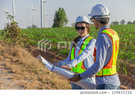 Engineer workers teamwork site survey at wind turbine farm project planning construction together. 124615158