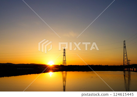 夕陽西下,稻田裡倒映著鋼塔的景象 夕陽西下,稻田裡倒映著鋼塔的景象 124615445