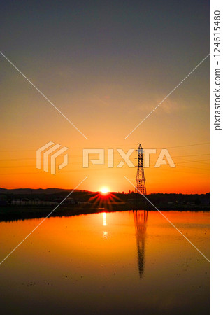 被水淹沒的稻田上倒映的落日和鋼塔 124615480