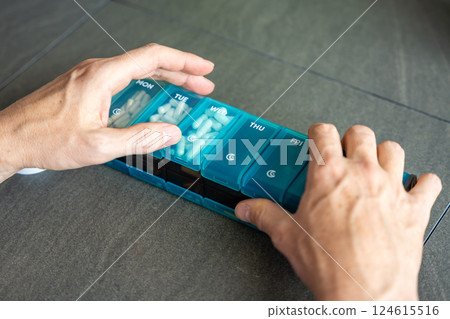 Weekly pill organizer with labeled compartments for daily medication doses. Concept of health management and medication planning 124615516