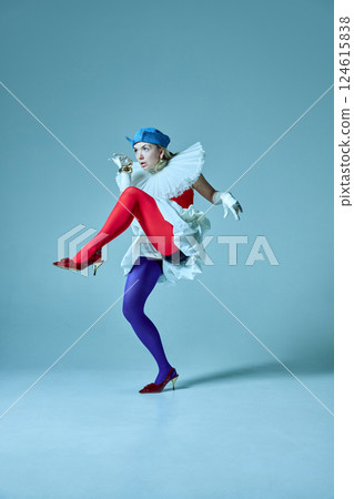 Woman in vibrant tights and structured outfit walking, with legs raised high, highlighting eccentric elegance. 124615838