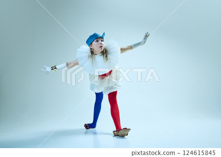 Young woman moving gracefully in red corset, exaggerated collar, and asymmetric tights, emphasizing balance and disarray. 124615845