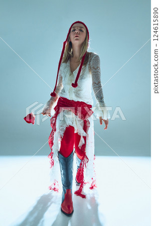 Woman in delicate white lace dress, red waist wrap, and pointed boots walks forward, holding rose, embodying journey of self-discovery. Woman in delicate white lace dress, red waist wrap, and pointed boots walks forward, holding rose, embodying journey of self-discovery. 124615890