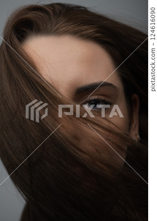 Beautiful woman with blue eyes cover her face with hair Beautiful woman with blue eyes cover her face with hair 124616090