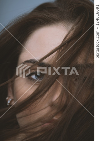 Beautiful woman with blue eyes cover her face with hair Beautiful woman with blue eyes cover her face with hair 124616091