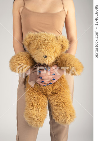 Woman holding fluffy bear toy in her hands 124616098