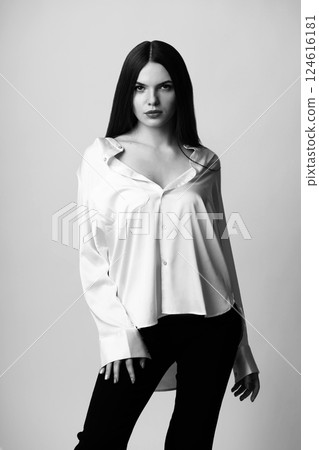 Beautiful woman with white blouse and black trousers studio portrait 124616181