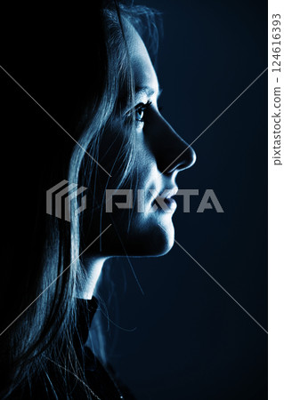 Low light side view of woman studio portrait 124616393