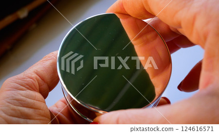 A woman's hand opens a jar of cream, tries a white face cream with her finger. 124616571