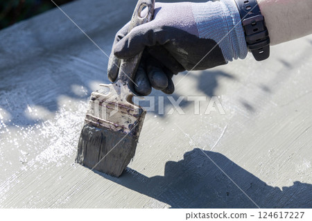 Male hand with paintbrush paints surface with green paint 124617227