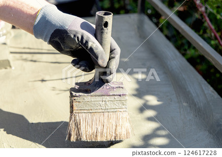 Male hand with paintbrush paints surface with green paint 124617228