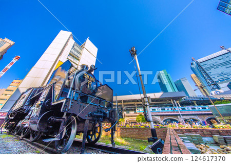 東京都市風景在日本看在Shimbashi駐地和摩天大樓前面的Shinbashi SL正方形在Shiodome 東京都市風景在日本看在Shimbashi駐地和摩天大樓前面的Shinbashi SL正方形在Shiodome 124617370