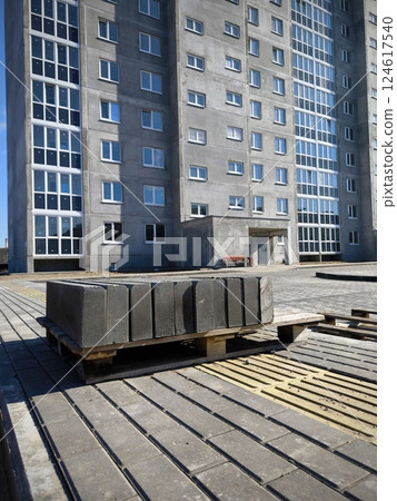 Storage of concrete road curbs on pallets at the construction site. Building construction pallets 124617540