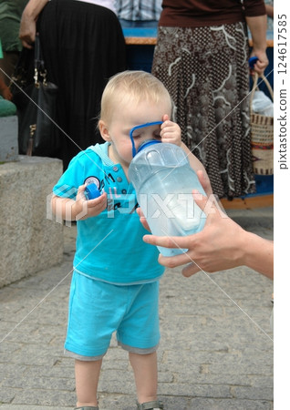 Toddler Drinking Water From a Large Bottle Outdoors 124617585
