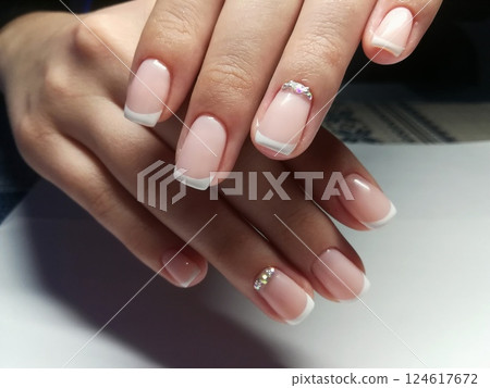 Pink natural nude look style womanly naildesign. Beautiful professional short naildesign on manicured healthy hands of european woman. Manicure gel polish nude and French 124617672