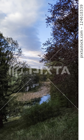 Scenic landscape of pruhonicky park in spring with cloudy sky, czech republic Scenic landscape of pruhonicky park in spring with cloudy sky, czech republic 124618339