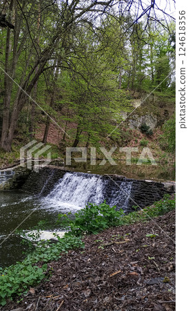 Waterfall cascading in pruhonice park, czechia, creating a serene oasis 124618356