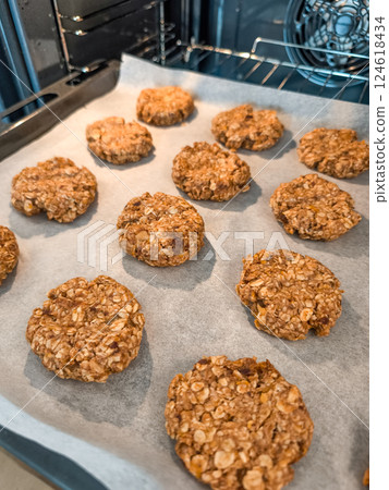 Freshly baked oatmeal cookies cooling on baking sheet 124618434