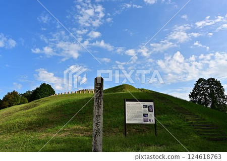 A beautiful ancient tomb surrounded by blue skies and fresh greenery 124618763