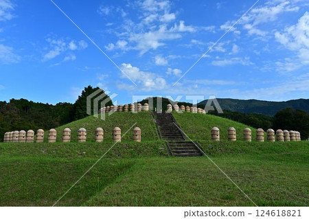 A beautiful ancient tomb surrounded by blue skies and fresh greenery 124618821