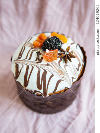A delicious Easter cake, adorned with a marbled chocolate and white icing, is decorated with dried fruits and spices. It's a festive treat perfect for the holiday 124619262